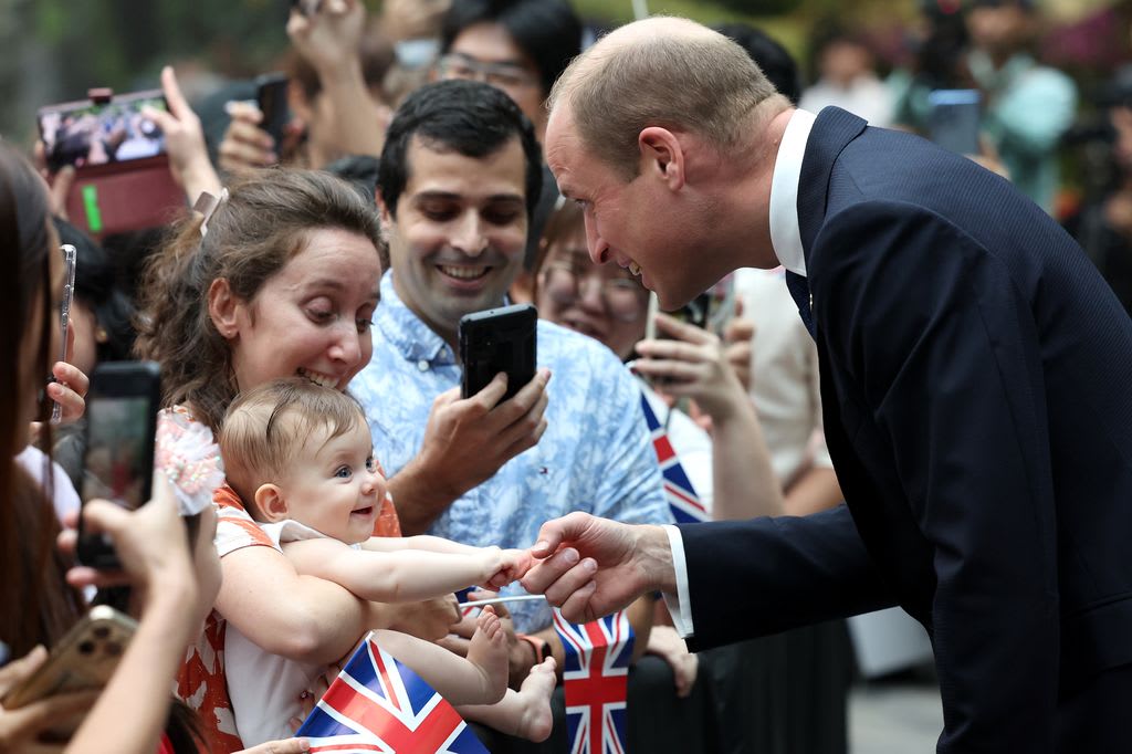 baby holding prince william's finger 
